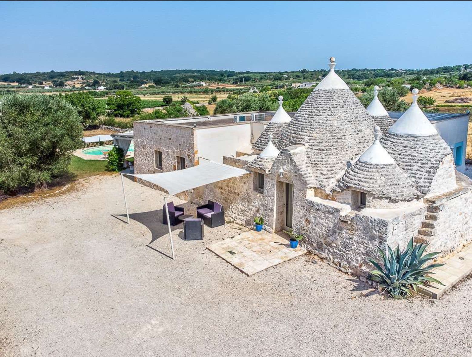 Vista aerea dei trulli in pietra di Villa Paradise circondati dagli uliveti della Valle d'Itria